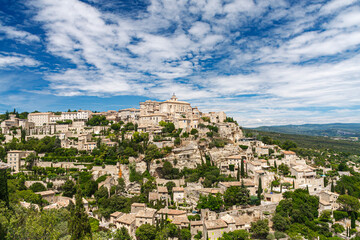 One of the most beautiful and famous village Gordes built on the foothills of the Monts of Vaucluse, facing the Luberon, under a cloudy sky in a sunny day in Avignon, Provence, France