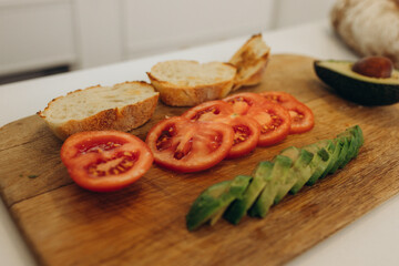 toast with avocado in the kitchen. Cooking breakfast
