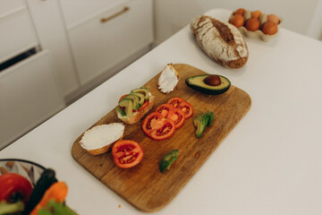 toast with avocado in the kitchen. Cooking breakfast