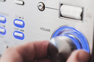 Male hand is on a volume control knob, close up-photo