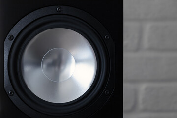 Shiny audio speaker in black body, close-up photo