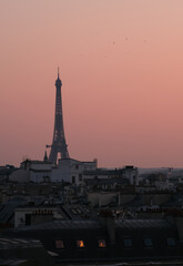 Obraz premium View of the stunning Eiffel Tower above the rooftops of Paris and a beautiful sunset