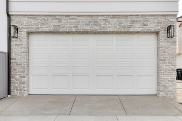 Two car garage with white door and white brick exterior.