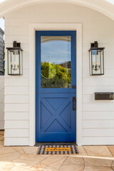Blue front door with light fixtures and a mail slot