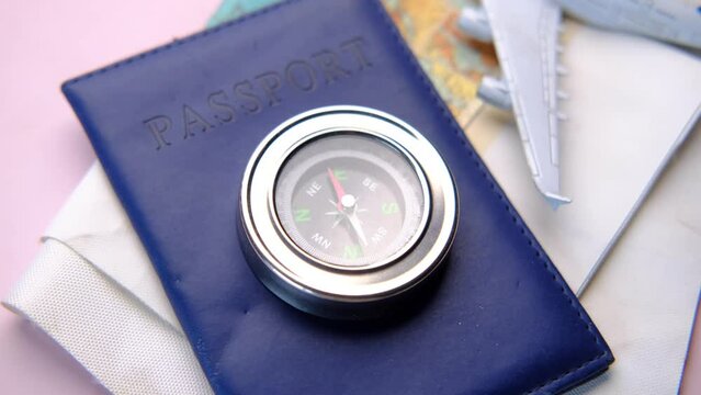 a passport, compus with travel map on table,