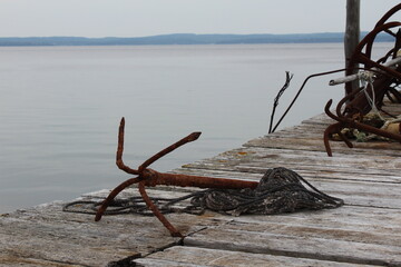 Nova Scotia weathered anchor on historical dock by ocean