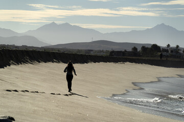 woman running in todos santos baja california beach