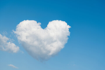 Obraz na płótnie Canvas White heart shaped cloud in the blue sky