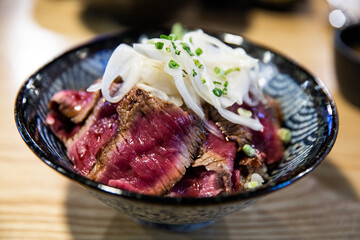Steak bowl with beef steak, rice, mustard, vegetables, green onion, and greens,