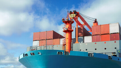 Front view of large blue container cargo ship. Performing cargo export and import operation.