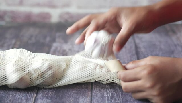 close up of taking garlic out from a reusable shopping bag 