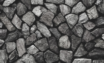Dark masonry wall texture. Black stones and rocks of different shape, gray background. Stonework.                          