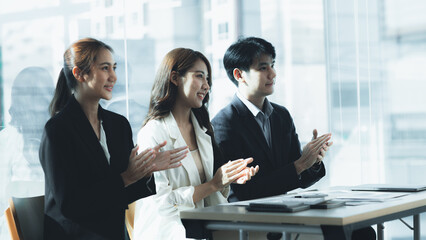 Business men and women clapping in the conference room, marketing department meeting staff presenting marketing plans to company executives. Marketing planning ideas and plans presentations.