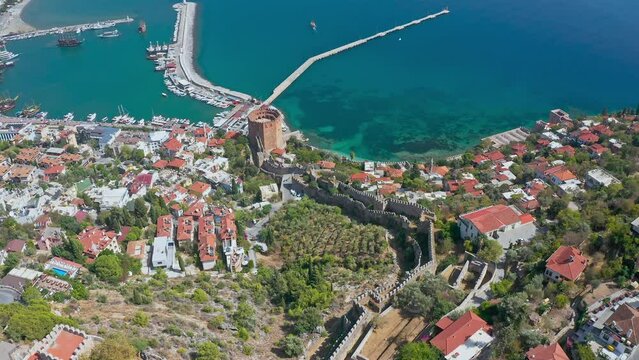 Panoramic view to the city of Alanya, marina, sea and mountains from the top of the fortress wall.  View of Alanya harbor from Alanya peninsula. Kizil Kule - main tourist attraction in Alanya. 