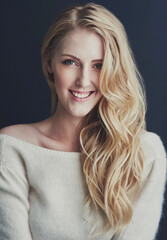 Her confidence shines through. Studio portrait of a smiling young woman isolated on black.