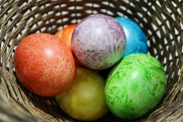 colorful easter eggs in a wooden wicker basket close up