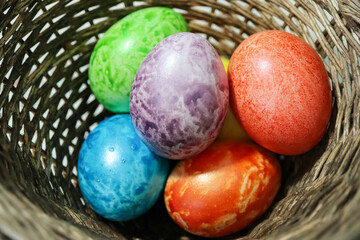 colorful easter eggs in a wooden wicker basket close up