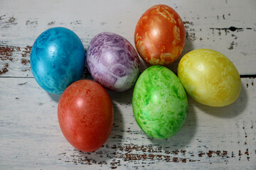colorful easter eggs on wooden kitchen table close up