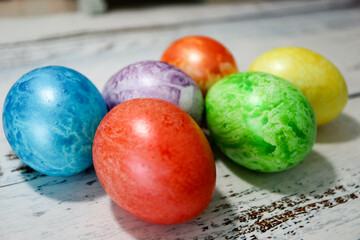 colorful easter eggs on wooden kitchen table close up