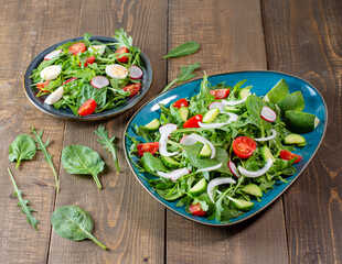 Salad with cherry tomatoes, fresh arugula and quail egg. Concept for a tasty and healthy meal. Vitamins in vegetables and herbs for immunity against the virus. Top view. Flat lay