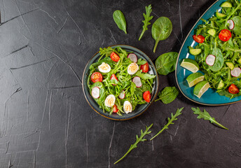 Salad with cherry tomatoes, fresh arugula and quail egg. Concept for a tasty and healthy meal. Vitamins in vegetables. Top view. Flat lay, copy space