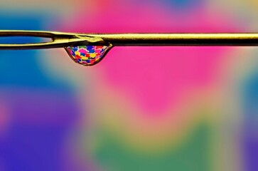 Macro de gota con reflejos en aguja de coser