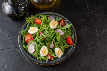 Fresh salad with arugula, cherry and eggs with olive oil and balsamic