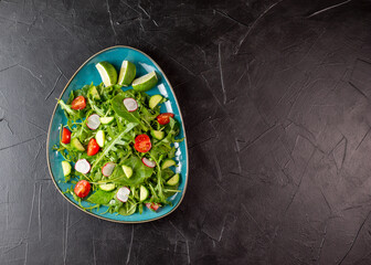 Salad with cherry tomatoes, fresh arugula and quail egg. Concept for a tasty and healthy meal. Vitamins in vegetables. Top view. Flat lay, copy space