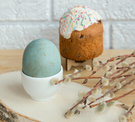 Easter egg, willow branch and cake on the table. Close-up. Selective focus