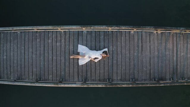 Arial view of a woman on the bridge at Henschotermeer lake in Woudenberg, Netherlands.