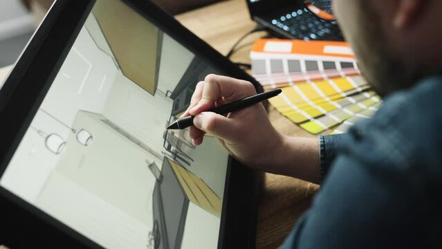 A professional architect draws a room sketch on a digital tablet. Creation of new spaces and interiors