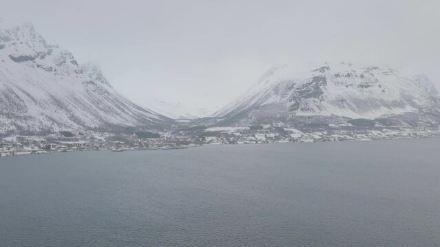 Aerial drone push in towards snow covered Olderdalen, Northern Norway.