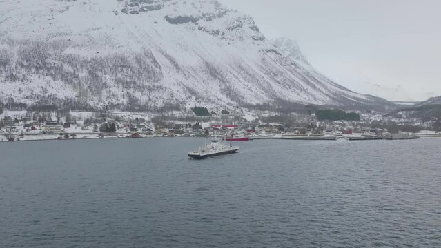 Aerial drone orbits ferry leaving Olderdalen. Kaafiord, Norway.