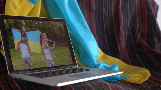 laptop with video conference and presentation near the flag of ukraine.