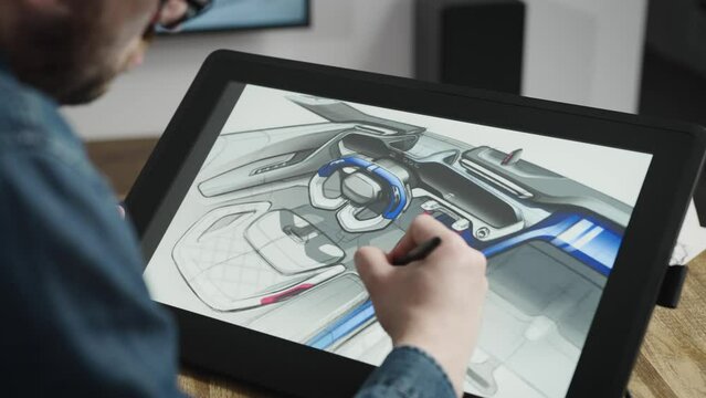 An industrial designer develops a new car interior concept. A man uses a professional graphics tablet to sketch.