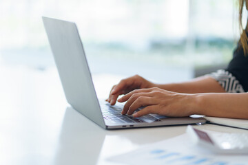 Businesswoman sitting using laptop computer with on the desk in the office.