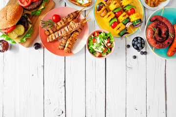 Summer BBQ or picnic food top border. Variety of burgers, grilled meat, vegetables, fruits, salad...