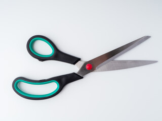 Open utility scissors with black plastic handles with green inserts