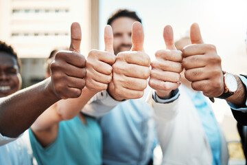 We can all agree. Shot of an unrecognisable group of businesspeople standing outside together and showing a thumbs up.