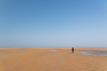 One person walking in an empty beach