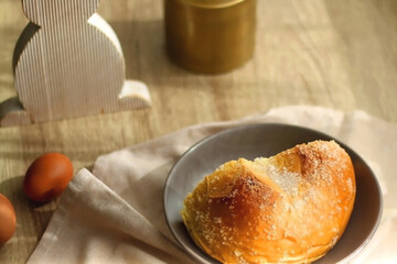 Plate of traditional sweet bread, eaten at Easter time in Croatia. Easter bunny, eggs and flowers on the table. Selective focus.