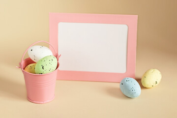 Easter composition from decorative bucket full of eggs and blank card with copy space on background.