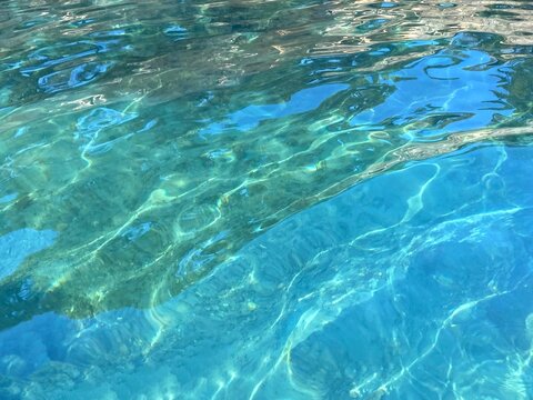 Transparent clear sea. Beautiful turquoise blue green watercolor. Glittering ripples ocean water surface.