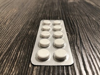 The pills lying on the wooden table. The pills close up.