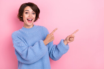 Photo of astonished positive lady direct fingers empty space proposition isolated on pink color...