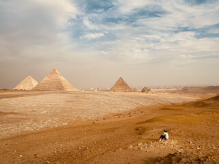 A traveler looks at the pyramids in the Giza plateau near Cairo, Egypt
