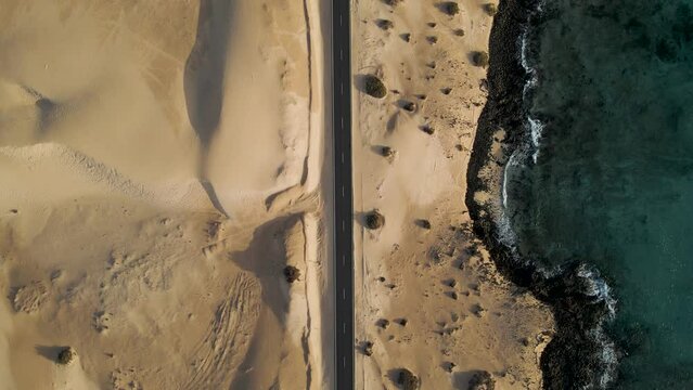 Aerial top down view of a road crossing the desert at Corralejo sand dunes natural park, Fuerteventura, Canary Islands, Spain.