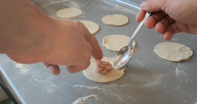 the chef puts the meat filling on the dough
