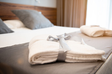 Fototapeta na wymiar A White bathrobe on the bed of room hotel