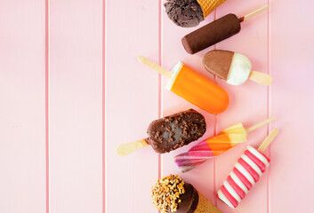 Mixture of chocolate and colorful summer popsicles and ice cream treats. Top down view side border...